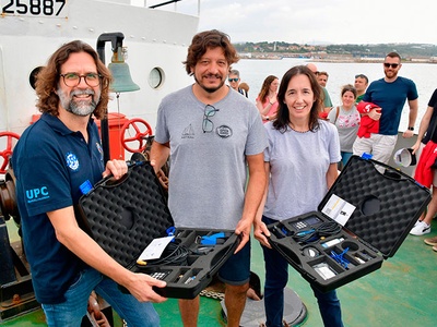 Xavier Martínez, de l'FNB; Martín Maretta, d'Open Arms, i Carmen Borja, de Fractus, amb l'equipament que permetrà reduir el consum de combustible durant la navegació