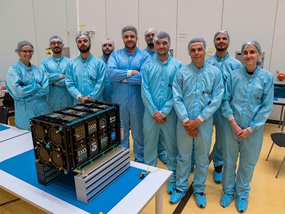 Els tres estudiants del NanoSat Lab davant del mòdul d'ExoPod Nova en el qual s'ha embarcat el el 3Cat-4, a les instal·lacions de Kourou.
