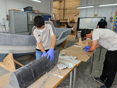 Estudiants de l'FNB (en primer pla) i de l'ETSETB (al fons) preparant l'acabament dels cascos dels seus minivelers
