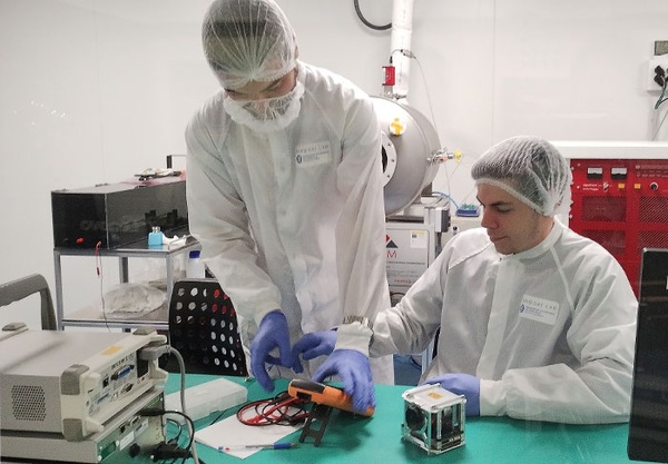 Doctoral candidates Guillem Gràcia i Solà and Amadeu Gonga i Siles with the space payload RITA/3Cat-6 at the clean room of the UPC NanoSat Lab.